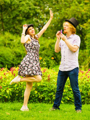 Fototapeta premium Couple blowing bubbles outdoor
