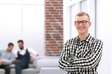 serious young man standing in spacious office