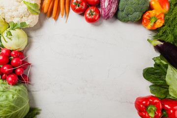 Stone background with a border of fresh vegetables.