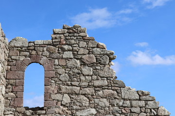 Window opening in old stone wall against blue  sky