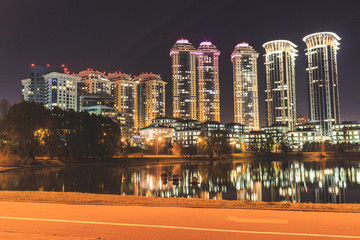 High-rise houses of a residential complex with night lighting. Expensive housing.