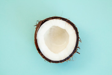 one half of ripe coconut on blue background,top view