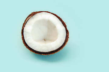 one half of ripe coconut on blue background,top view