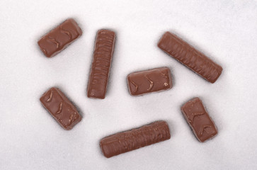 White sugar background, candy bars in sugar