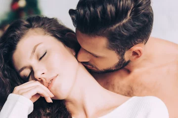 Fotobehang close up view of man kissing beautiful girlfriend in neck © LIGHTFIELD STUDIOS