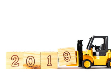 Toy forklift hold letter wood block 9 to complete word 2019 on white background (Concept for happy new year 2019)