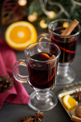 Mulled wine in glass with spices at dark background