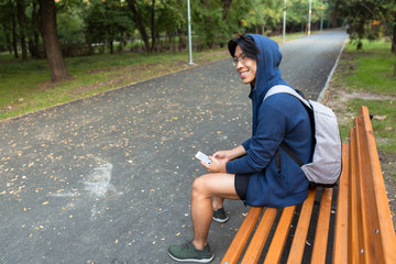 Smiling young asian man dressed in hoodie