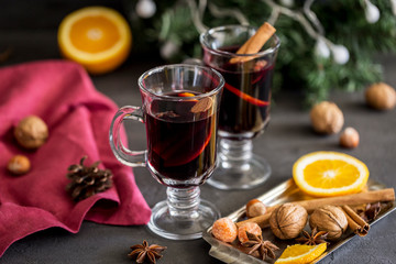 Mulled wine in glass with spices at dark background