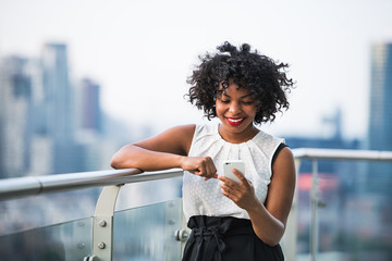 A businesswoman standing against London view panorama, using telephone.