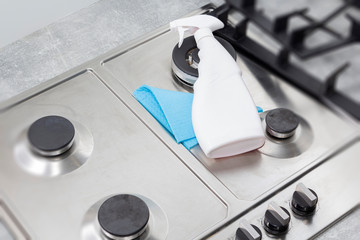 Cleaning a gas stove with kitchen utensils, household concepts, or hygiene and cleaning.