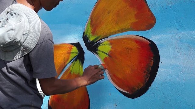 Mural painter paints butterfly