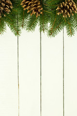 Branch of spruce and cones on a wooden background