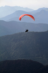 Paraglider in front of a mountain range panorama in the alps