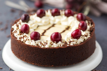 Chocolate cheesecake decorated cherry and whipped cream