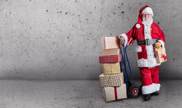 Santa Claus with gifts on trolley with copy space
