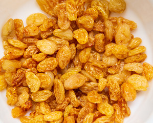 Yellow raisins in a plate as background