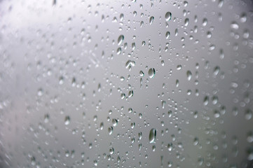Drops of water on the glass. Rain. Part of the image is blurred.