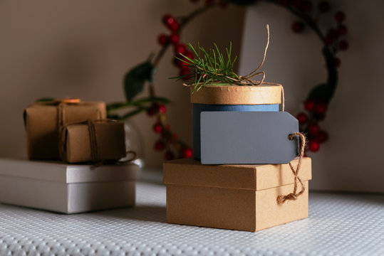 stacked Gifts boxs, wrapped in recycled paper and empty tag on white table
