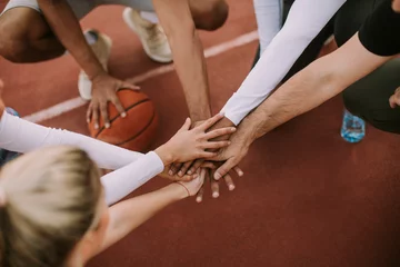 Zelfklevend Fotobehang Top view of basketball team holding hands over court © BGStock72