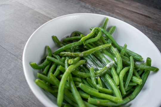 whole green beans with butter in white bowl