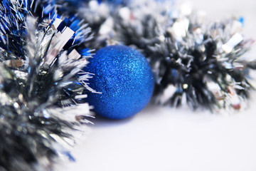 blue tinsel and blue Christmas ball on white background