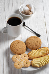 Various cookies and coffee on white table