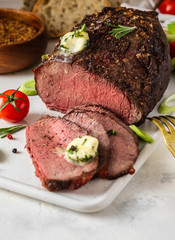 Roast beef with sauce and meat fork on white background. Copy space.