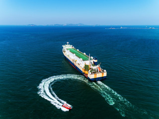 Aerial view Tug boats finish drag carry car ship or cargo ship to sea  for import  export or transportation concept background.