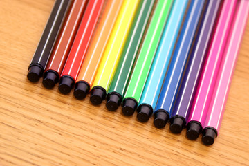 Set of colored markers on a wooden surface