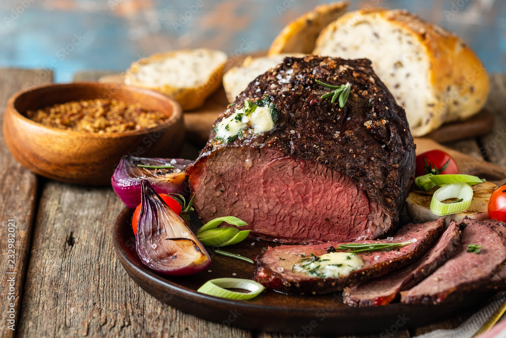 Wall mural Roast beef on cutting board. Wooden background. Copy space.