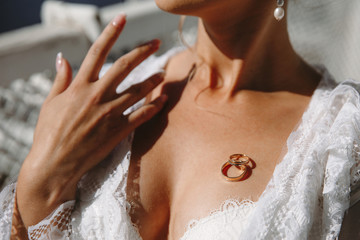 wedding rings lie on the chest of the bride