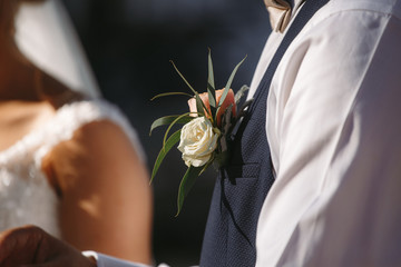 groom's boutonniere of white roses, flower on the groom's jacket - Powered by Adobe