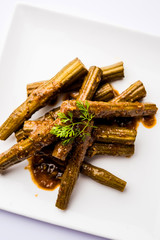 Drumstick masala or Shevga sheng sukhi sabji, served in a plate over moody background. Selective focus