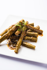 Drumstick masala or Shevga sheng sukhi sabji, served in a plate over moody background. Selective focus