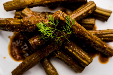 Drumstick masala or Shevga sheng sukhi sabji, served in a plate over moody background. Selective focus