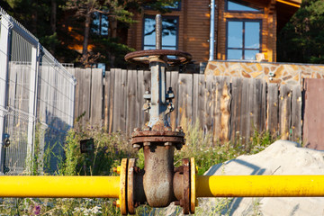 Fototapeta na wymiar Yellow gas pipe with valve, faucet, in the village