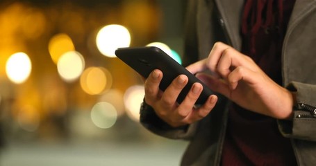 Close up of a fashion woman hands browsing smart phone content in the night in the street
