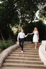 Young couple walking in the park. The have fun and rejoice. Black and white clothes