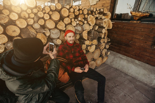 Self-confident Photographer Does Portrait Of Man By The Phone On Background Of Sawmill And Warehouse Of Trees