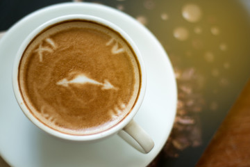 Closeup of A cup of Latte Art hot coffee over wooden  table top background in coffee's shop