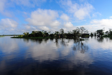 Wasserspiegel des Amazonas mit blauem Himmel und weissen Wolken
