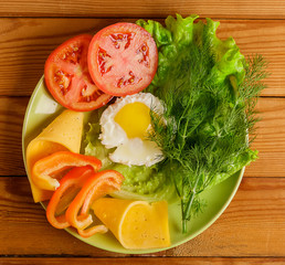 Fried eggs and pieces of vegetables on the table.