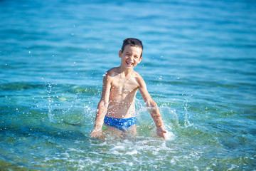 Little boy with snorkel by the sea. Cute little kid wearing mask and flippers for diving at sand tropical beach. Ocean coast.