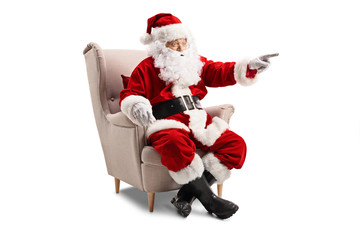 Santa Claus sitting in an armchair and pointing