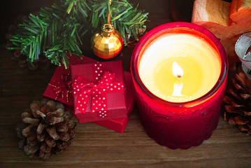 Red gift boxes and candle under christmas tree