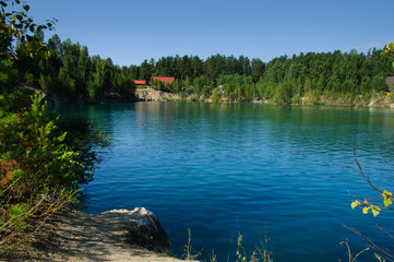 Obraz premium mountain lake in the summer at noon with vacationers and swimming tourists
