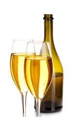 Two glasses of champagne on the background of brown bottles close-up isolated on a white.