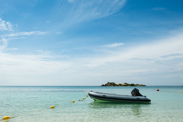 Fototapeta na wymiar inflatable rubber motor boat floating on blue sea with blue sky background, Samae San island, Sattahip, Chon Buri, Thailand, copy space