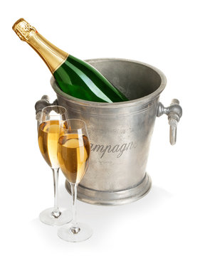 Champagne bottle in ice bucket with glasses of champagne isolated.